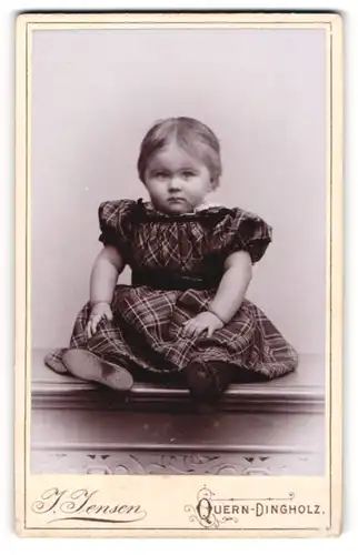 Fotografie J. Jensen, Quern-Dingholz, Portrait sitzendes Kleinkind im karierten Kleid