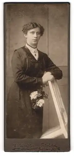 Fotografie Ad. Winkler, Görlitz, Portrait bürgerliche Dame mit Blume an Stuhl gelehnt