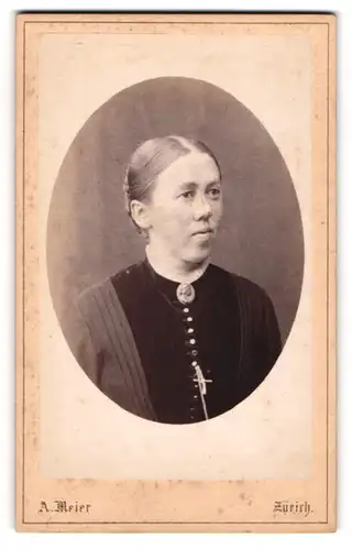 Fotografie A. Meier, Zürich, Frau in dekorativer Tracht mit Brosche