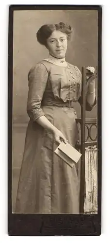 Fotografie Chr. Hansen, Schleswig, Frau in dunklem Kleid mit Buch in der Hand