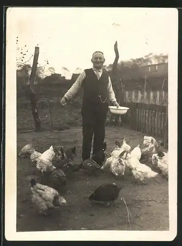 Fotografie Kleinbauer füttert seine Hühner