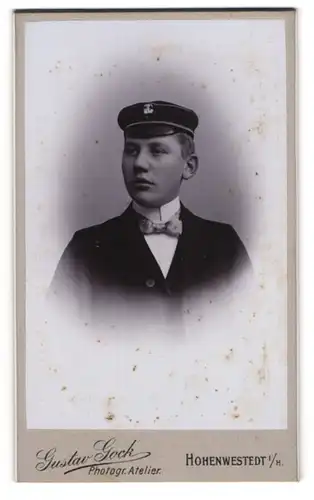 Fotografie Gustav Gock, Hohenwestedt i. H., junger Student im Anzug mit Fliege und Schirmmütze