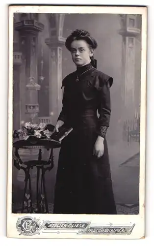 Fotografie P. Gliese, Reichenau i. S., junge Frau zu ihrer Kommunion im schwarzen Kleid, Studiokulisse