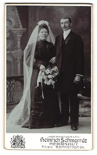Fotografie Heinrich Schmorrde, Herrnhut, Braut im schwarzen Brautkleid und im Anzug mit Brautstrauss