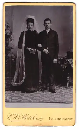 Fotografie E. W. Matthias, Seifhennersdorf, Ehepaar am Hochzeitstag im schwarzen Brautkleid und Anzug