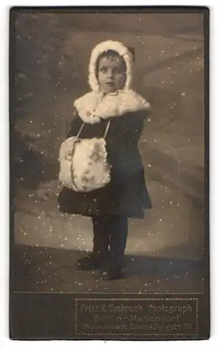 Fotografie Fritz K. Embruch, Berlin-Mariendorf, niedliches kleines Mädchen im Winterkleid mit Muff, Montage mit Schnee