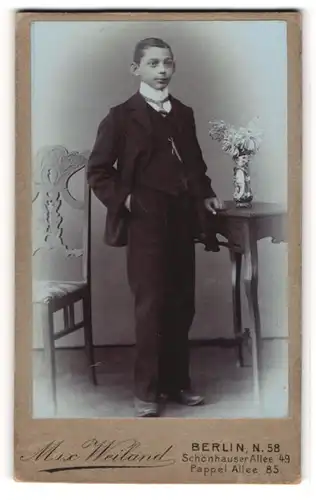 Fotografie Max Weiland, Berlin, Schönhauser Allee 49, Junger Bursche in schwarzem Anzug mit weissem Stehkragen