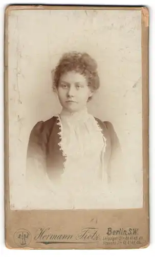 Fotografie Hermann Tietz, Berlin, Leipziger Str. 46, Junge Dame in weissem Kleid mit rundem schönen Gesicht und Locken