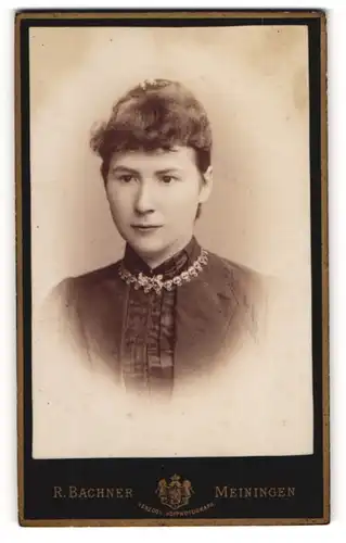 Fotografie R. Bachner, Meiningen, Georgstr. 22, Junge Dame in dunklem Kleid mit Hochsteckfrisur und silberner Kette