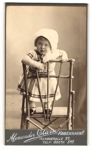 Fotografie Alexander Clark, Kobenhavn, Falkoneralle 57, Kleines Kind im Kleid steht auf Stuhl