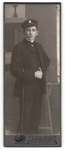 Fotografie Gustav Gock, Hohenwestest i. H., Student mit Flanierstock im dunklen Anzug, Couleur an Schirmmütze
