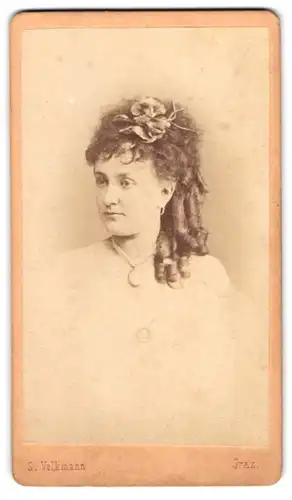 Fotografie S. Volkmann, Graz, junge Frau mit Korkenzieherlockne und Blume im Haar