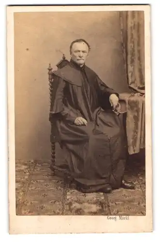 Fotografie Georg Märkl, Wien, Priester im Gewand sitzend im Stuhl