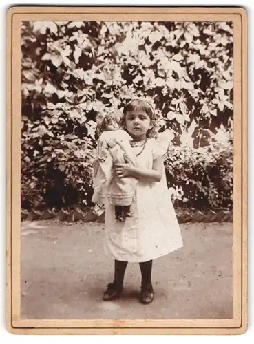 Fotografie unbekannter Fotograf und Ort, Mädchen Edith mit ihrer Puppe im Arm, 1900