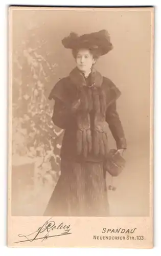 Fotografie Rolus, Spandau, junge Frau im Winterkleid mit Pelzschal und Hut, Muff