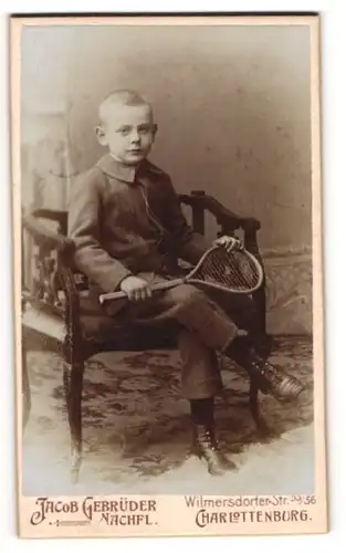 Fotografie Jacob Gebrüder, Charlottenburg, Wilmersdorfer-Str. 55 /56, Hübscher Junge in lässiger Pose mit Tennisschläger