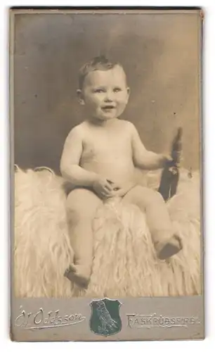 Fotografie Ol. Oddsson, Faskrubsfirdi, Nacktes Kleinkind sitzt auf einem Fell