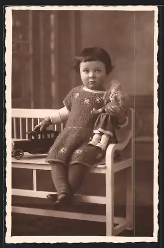 Foto-AK Mädchen im Strickkleid mit Blechauto und Puppe