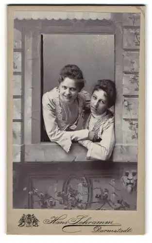 Fotografie Hasn Schramm, Darmstadt, zwei junge Fraun schauen aus einem Fenster, Studiokulisse