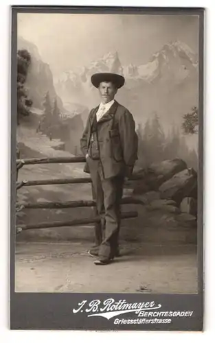 Fotografie J. B. Rottmayer, Berchtesgaden, Herr im Anzug für einer Studiokulisse, Tracht