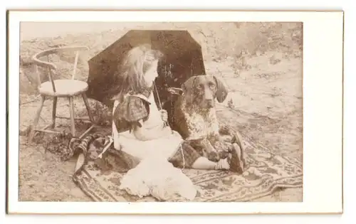 Fotografie unbekannter Fotograf und Ort, kleines Mädchen mit ihrem Jagdhund auf einem Teppich im Garten