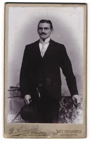 Fotografie Gotthold Sauer, Wittenberg, Mann stehend mit Schnurrbart, Zylinder und Gehstock