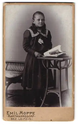 Fotografie Emil Hoppe, Hartmannsdorf, Portrait junges Mädchen im Matrosenkleid mit Zeitung an Tisch gelehnt