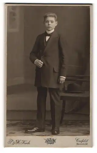 Fotografie P. & H. Koch, Crefeld, Portrait junger Mann im Anzug mit Fliege