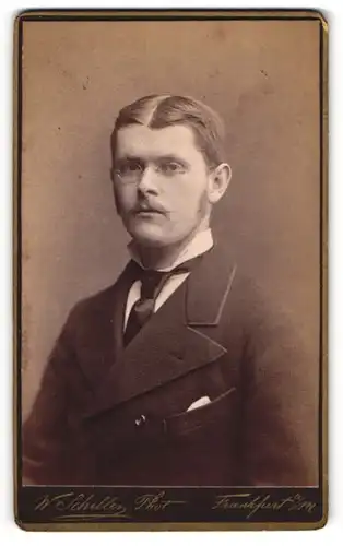 Fotografie W. Schiller, Frankfurt a / M., Portrait modisch gekleideter Herr mit Brille und Zwirbelbart