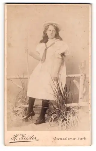 Fotografie H. Zeidler, Berlin-SW, Portrait junge Dame in hübscher Kleidung an Zaun gelehnt