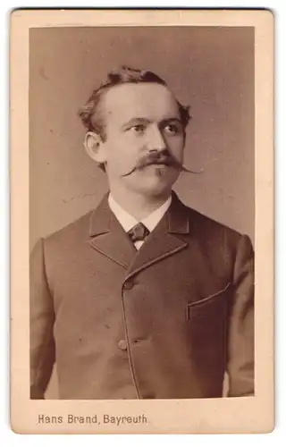 Fotografie Hans Brand, Bayreuth, Portrait junger Herr im Anzug mit Fliege und Zwirbelbart