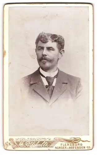 Fotografie M. B. Schultz, Flensburg, Portrait modisch gekleideter Herr mit Schnauzbart