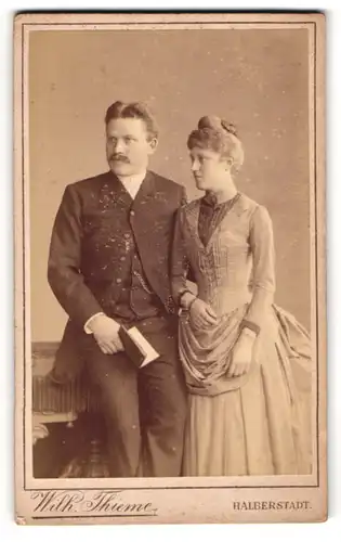 Fotografie Wilh. Thieme, Halberstadt, Portrait bürgerliches Paar in eleganter Kleidung mit Buch