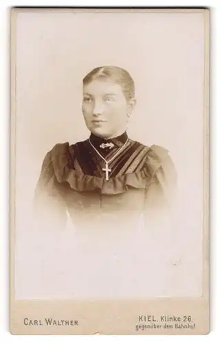 Fotografie Carl Walther, Kiel, Portrait junge Dame im eleganten Kleid mit Kreuzkette