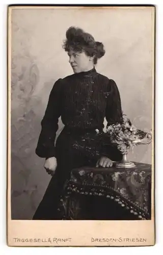 Fotografie Taggesell & Ranft, Dresden-Striesen, Portrait modisch gekleidete Dame an Tisch gelehnt