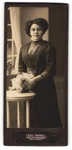 Fotografie Emil Hoppe, Hartmannsdorf, Portrait bürgerliche Dame mit Blumen an Tisch gelehnt