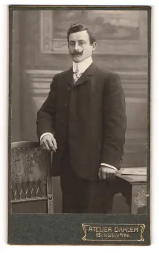 Fotografie Atelier Dahlem, Bingen a / Rh., Portrait junger Herr im Anzug mit Krawatte und Schnauzbart