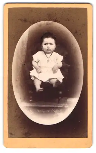 Fotografie Anton Fischer, Coburg, Portrait niedliches Kleinkind im weissen Kleid mit nackigen Füssen