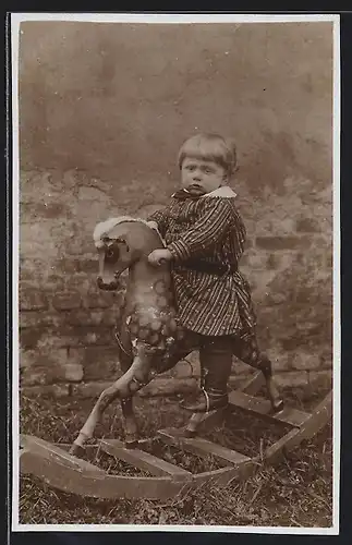 Foto-AK Kleines Kind auf einem Schaukelpferd