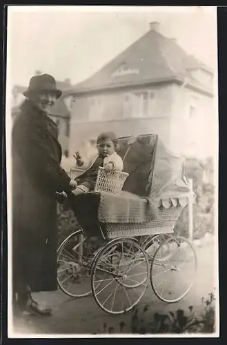 Foto-AK Frau im Mantel mit Kinderwagen auf der Strasse