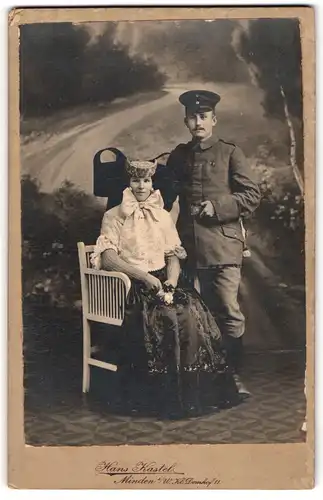 Fotografie Hans Kastel, Minden i. W., Soldat in Uniform nebst Frau in Tracht mit Schleife