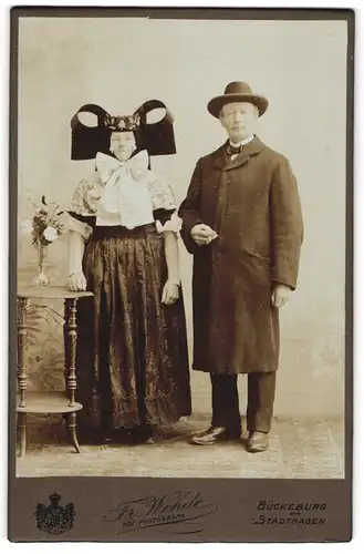 Fotografie Fr. Wehde, Bückeburg, Frau in Bückeburger Tracht nebst ihrem Mann