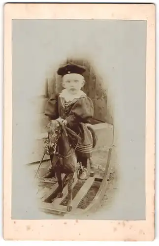 Fotografie unbekannter Fotograf und Ort, kleines Kind auf seinem Schaukelpferd