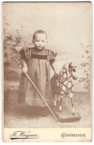 Fotografie Fr. Wagner, Lüdenscheid, niedliches kleines Mädchen mit Holzpferd im Atelier