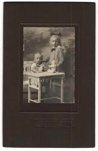 Fotografie Alfred Richter, Radebeul, Mädchen mit Geschwisterchen und Plüschkatze auf dem Tisch