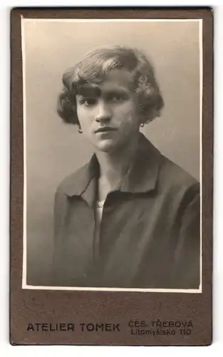 Fotografie Atelier Tomek, Ceska Trebova, Litomysiska 110, Junge Dame in grauem Mantel mit Locken und Ohrringen