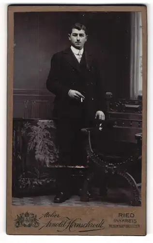 Fotografie Arnold Hirnschrodt, Ried, Bürgerlicher Herr in dunklem Anzug mit Hut und Zigarette in der Hand