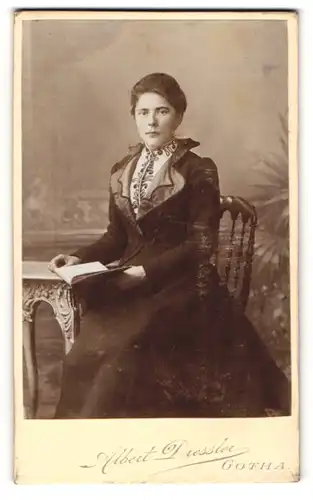 Fotografie Albert Dressler, Gotha, Portrait bürgerliche Dame mit Buch am Tisch sitzend