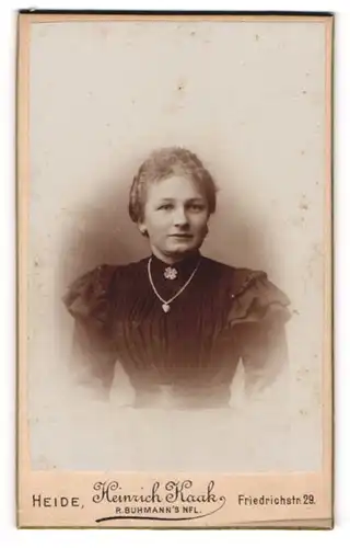 Fotografie Heinrich Kaak, Heide, Portrait junge Dame im eleganten Kleid mit Herzkette