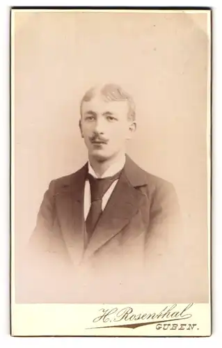 Fotografie H. Rosenthal, Guben, Portrait junger Herr im Anzug mit Krawatte und Schnurrbart